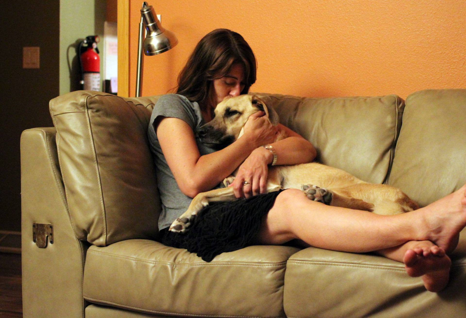 A woman holding her dog, bracing for the inevitable day of losing a pet